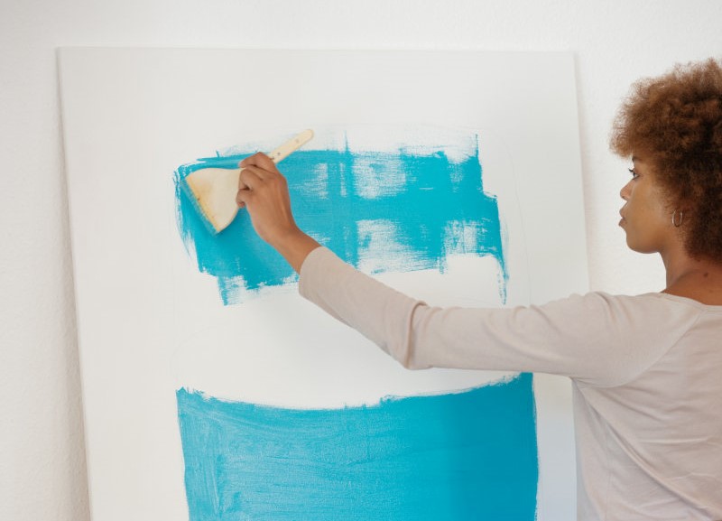 Acrylfarbe mit Spachtel auftragen Frau benutzt Spachtel für Acrylfarbe