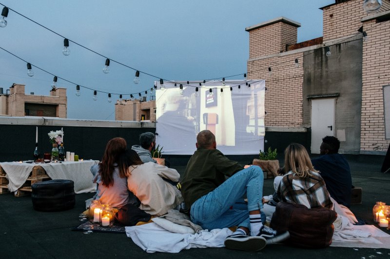 Personen vor Beamer Leinwand im Freien