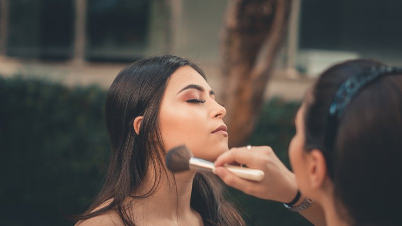 Foundation und Make-up im Gesicht. Foundation wird im Gesicht aufgetragen mit einem Pinsel.