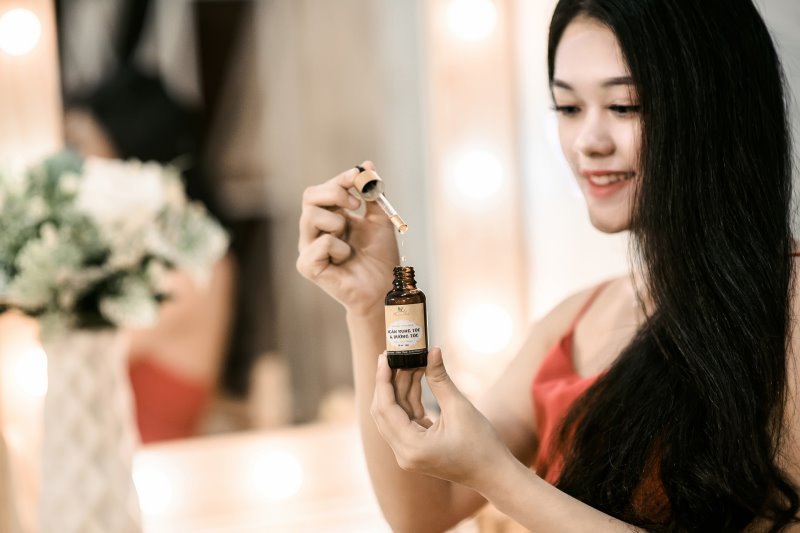 Frau mit Haarölflasche