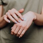 Handcreme auf Händen verteilen