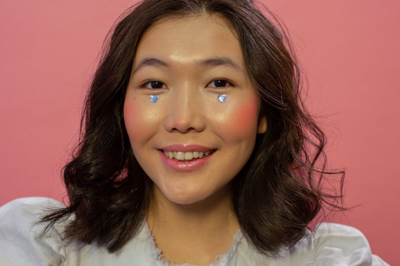 Highlighter im Gesicht Glückliche Frau mit Highlight