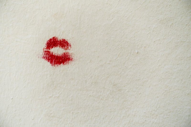 Roter Lippenstift-Kussmund Abdruck auf einer Wand