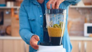 Früchte wie Kiwis werden im Smoothie-Maker zusammengemixt werden