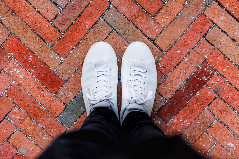 Weiße Sneaker auf der Straße Weiße Sneaker