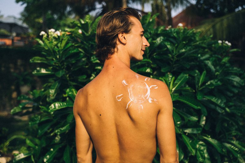 Sonnenschutz auf der Haut. Sonnencreme auf der Schulter einer Person.