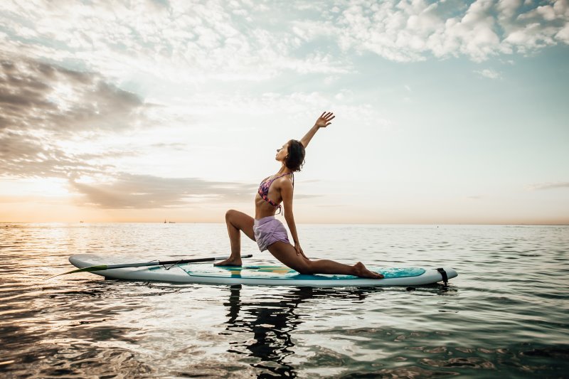 Frau macht Yoga-Übung auf SUP