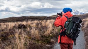 Mann fotografiert Landschaft in teurer Marken Jacke