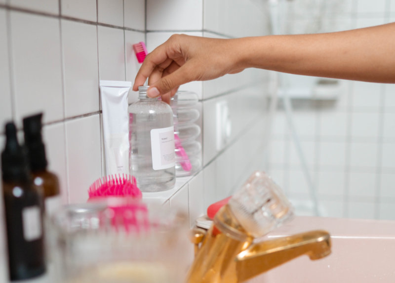 Toner steht im Badezimmer bei anderen Pflegeprodukten.