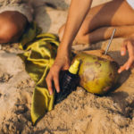 Sonnenöl Sprühflasche im Sand