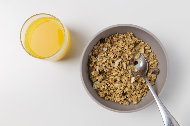 Schüssel mit Müsli und Orangensaft