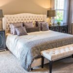Doppelbett mit vielen Kissen und Sitzbank
