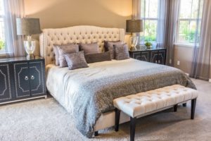 Doppelbett mit vielen Kissen und Sitzbank