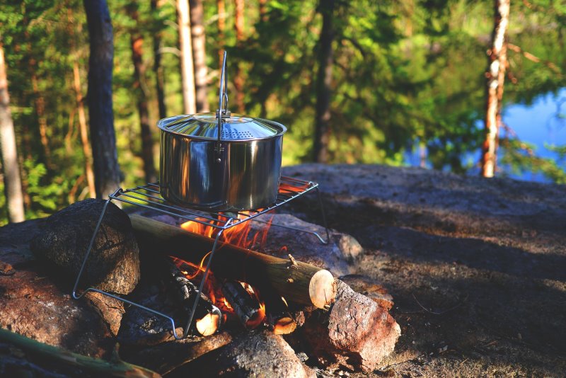 Camping-Kochgeschirr am Feuer Camping-Kochgeschirr am Feuer
