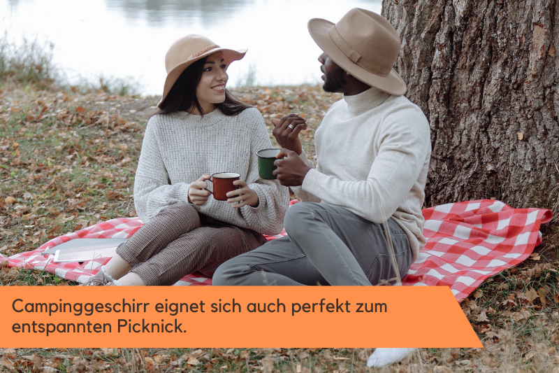 Paar picknickt und benutzt Camping-Tassen
