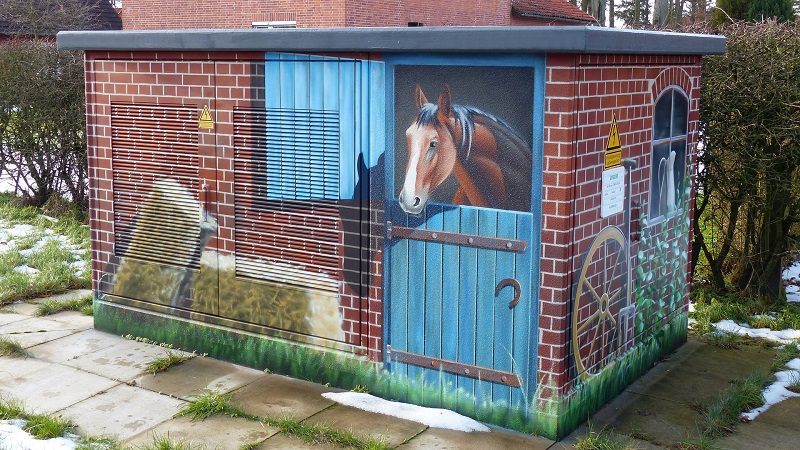 Ein Transformer auf den mithilfe einer Airbrush das Bild eines Stalls gemalt wurde