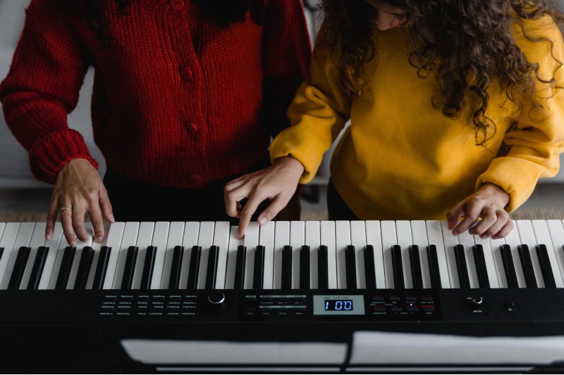 Schülerin und Lehrerin am Keyboard Keyboard lernen mit Lehrer