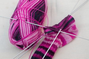 Eine Socke wird mit Strumpfstricknadeln gestrickt