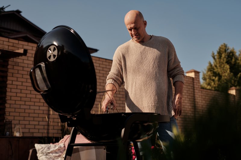 Mann grillt mit Kugelgrill