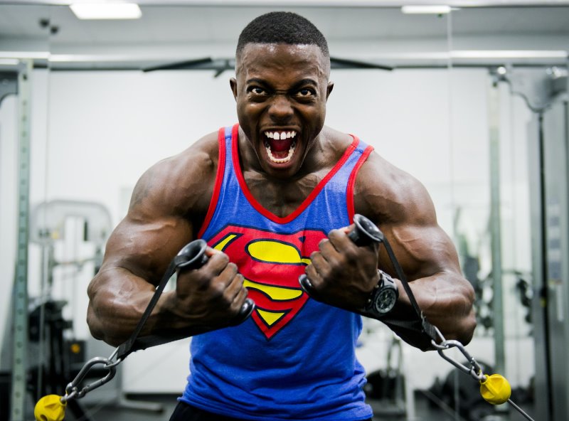 Mass Gainer für Zunahme an Muskeln Mann beim Training am Kabelzug