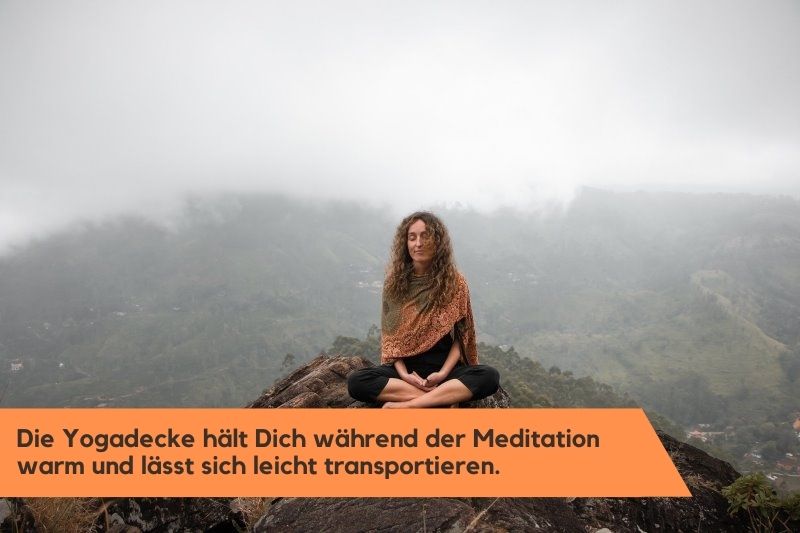 Frau meditiert mit Yogadecke in den Bergen