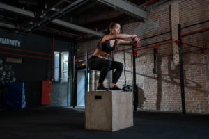 Eine Frau beim plyometrischen Training mit einer Sprungbox.