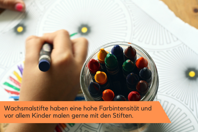 mit Wachsmalstiften wird ein Mandala ausgemalt