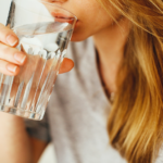 Eine Frau die Wasser trinkt.
