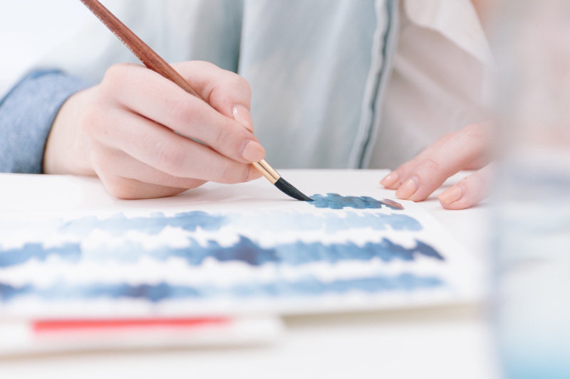 Aquarell-Malen mit einer Technik Aquarell-Malen mit Aquarellpinsel und blauer Farbe