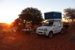 Auto mit Dachzelt bei Sonnenaufgang